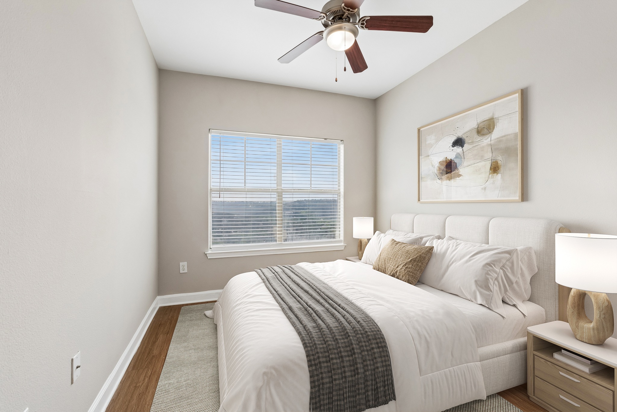 A bedroom with a bed, nightstand, and a ceiling fan.